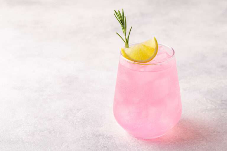 pink flavoured nonalcoholic drink with piece of lime for a good taste