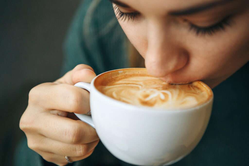 woman is drinking cup of coffee
