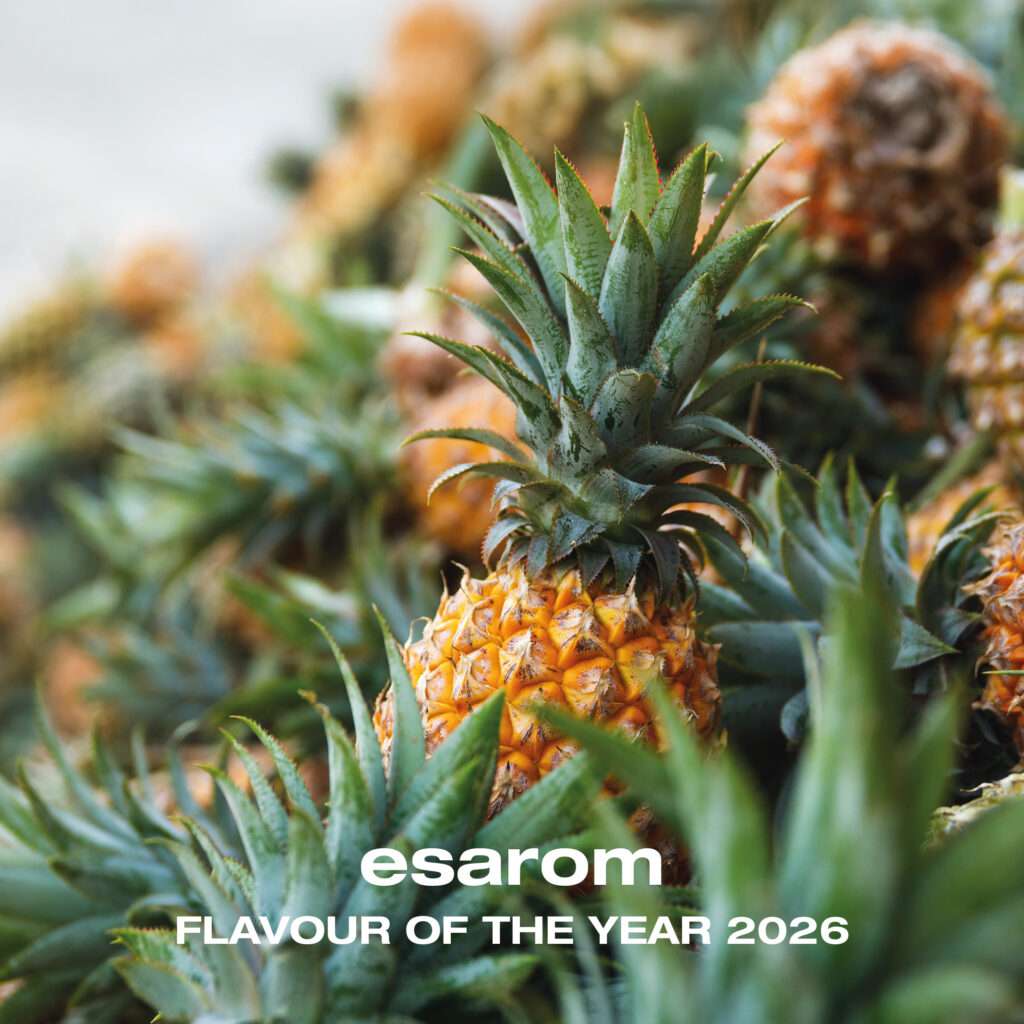 Close up of several ripe pineapples with green leaves, featuring the text "esarom FLAVOUR OF THE YEAR 2026" overlaid at the bottom—an enticing glimpse into prosweets innovation.