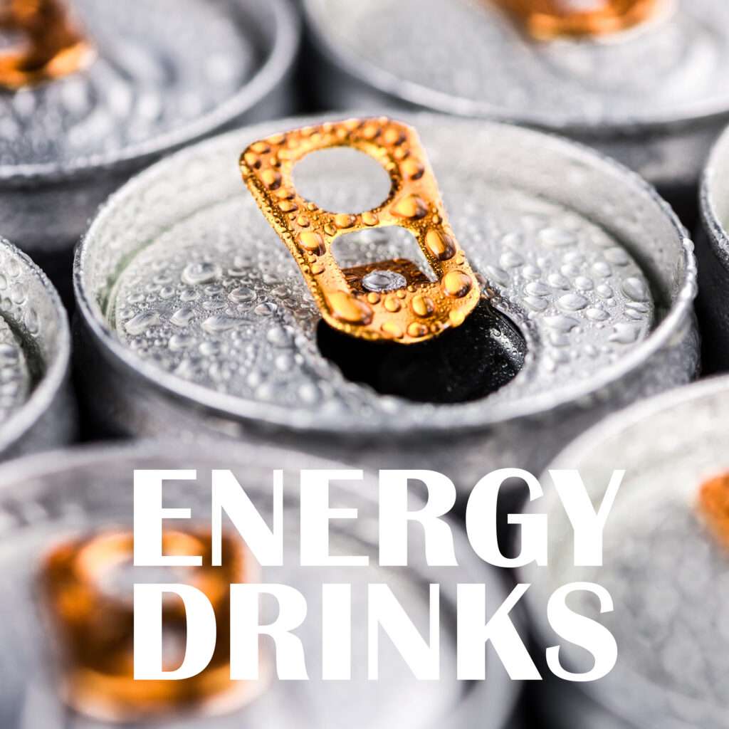 Close up of silver energy drink cans with orange pull tabs, covered in condensation. The words "ENERGY DRINKS" are boldly written across the bottom of the image.