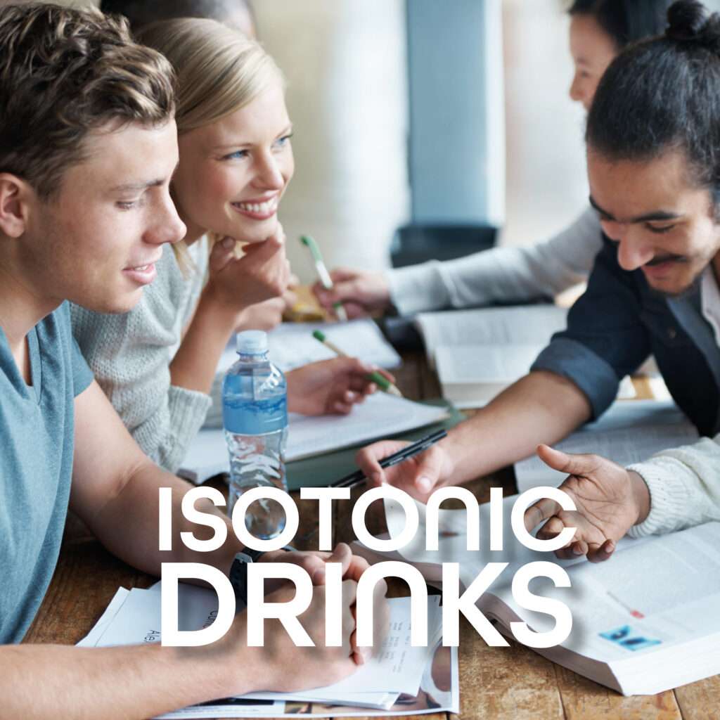 A group of young adults sitting at a table with books and notebooks, smiling and studying together. A bottle of isotonic drink is on the table, with bold text reading "ISOTONIC DRINKS.